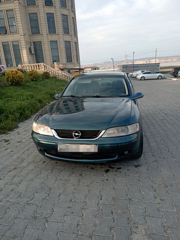 Tünd yaşıl rəngdə, dördqapılı sedan kuzalı Opel Vectra avtomobili