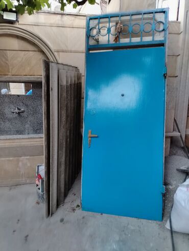 qapı tutacağı: Mavi rəngdə metal qapı, yuxarı hissəsində dekorativ metal barmaqlıqlar