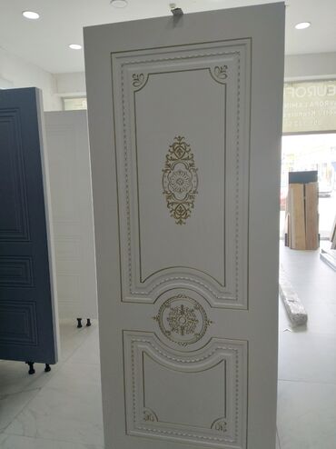 ağ qapılar: Ağ rəngli qapı paneli, qızılı rəngli naxışlarla bəzədilmişdir. Panelin