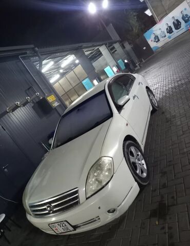 nissan tiana: Автомобиль Nissan Teana белого цвета. Это седан среднего размера