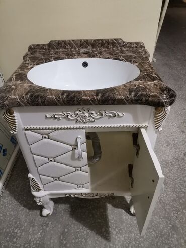 hamam moydadır: Ağ rəngli, oyma naxışlı ayaqları və detalları olan vanna otağı dolabı