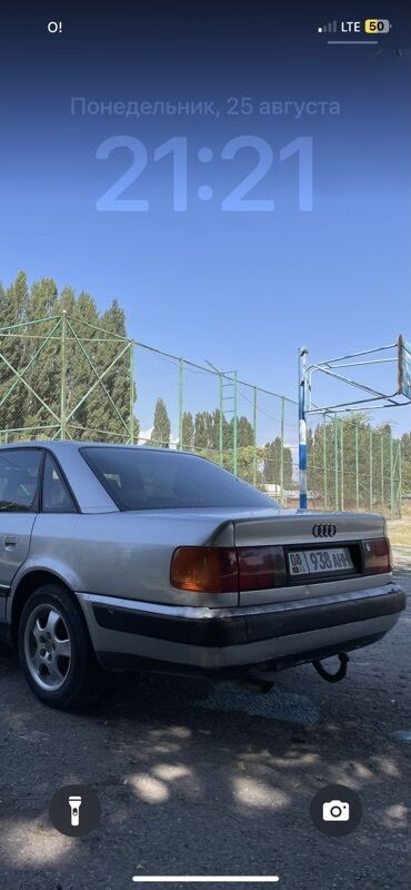 авто рага: Серебристый седан Audi 100 с характерным дизайном кузова. Автомобиль