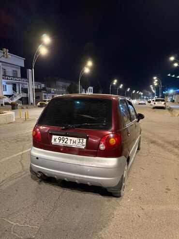 маленькая машина: Компактный хэтчбек Daewoo Matiz красного цвета, припаркованный на