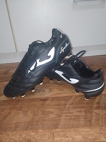 Kopačke: Kopačke Joma Aguila – crno‑bele - Model: Joma Aguila (logo i natpis — 1