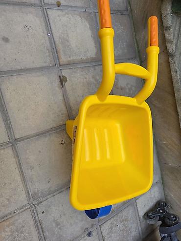 Oyuncaq traktorlar: Uşaq üçün plastik bir təkərli arabanın təsviri - Parlaq sarı gövdə və — 1