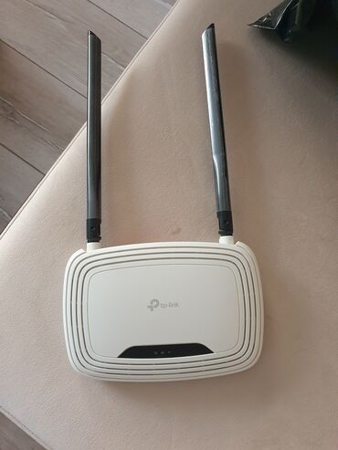 Printerlər: Ağ rəngdə, iki xarici antenası olan TP-Link markalı simsiz router. Bu