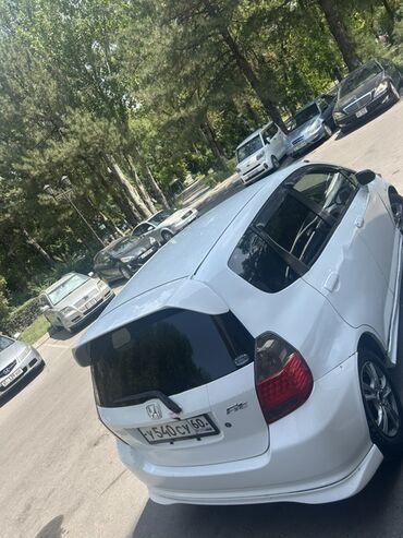 машиналар арзан: Белый хэтчбек Honda Fit с обтекаемым дизайном и задним спойлером