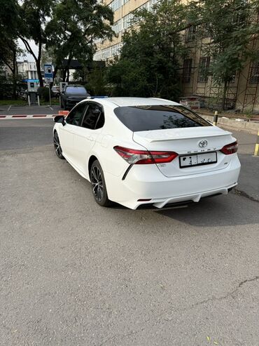 авто в рассрочку: Белый седан Toyota Camry с динамичным дизайном и стильными