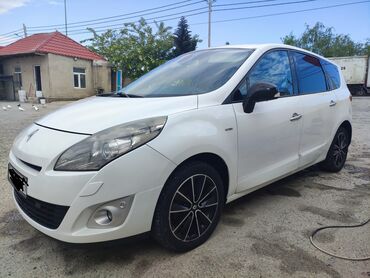 Ağ rəngdə, dördqapılı Renault Scenic minivan modeli. Avtomobilin ön