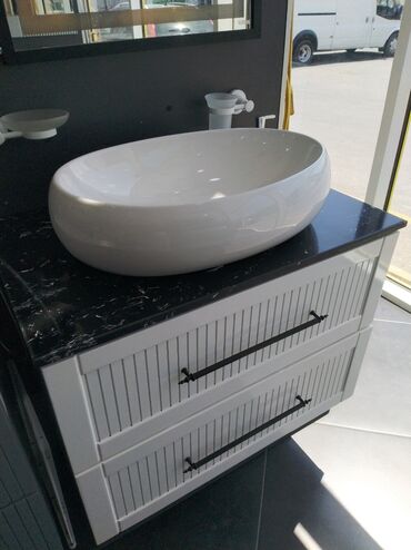 dam ortuyu formalari: Oval formalı, ağ rəngdə olan keramika lavabo. Qara mərmər görünümlü