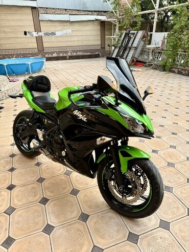мото дождевик: Мотоцикл Kawasaki Ninja, выполненный в яркой черно-зеленой расцветке