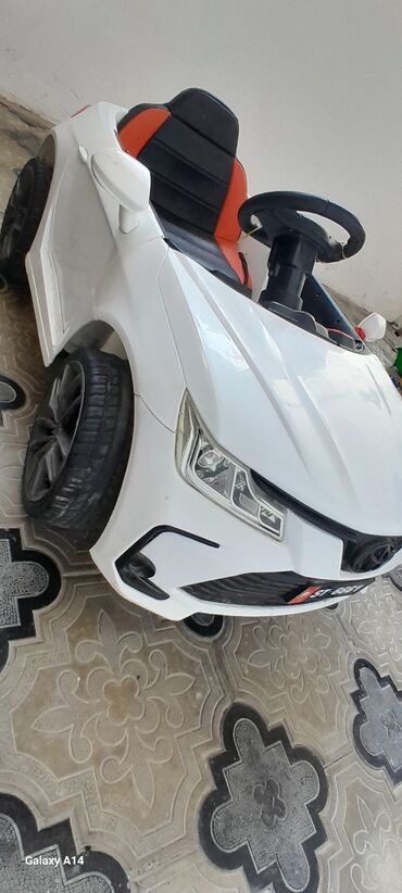 uşaq avtomobilleri: Uşaqlar üçün nəzərdə tutulmuş ağ rəngli elektrikli avtomobil. Bu maşın