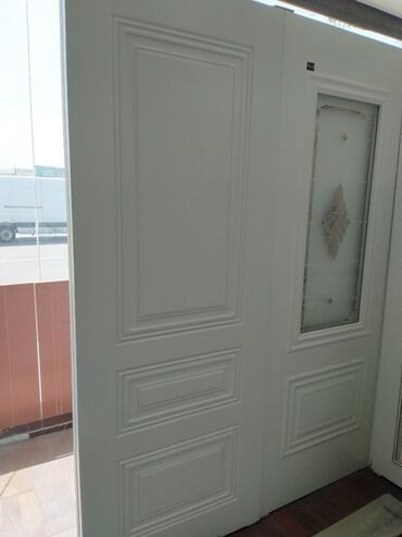 Bunker qapıları: Ağ rəngli taxta qapı, düzbucaqlı panelləri və şüşə detalları ilə