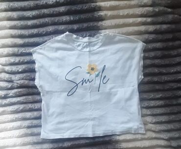 Pencəklər: Bu ağ rəngli qadın t-shirti sadə və rahat geyim üçün idealdır. Qısa