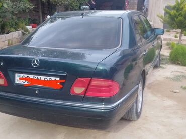 Tünd yaşıl rəngli, 4 qapılı Mercedes-Benz E-Class sedan avtomobili