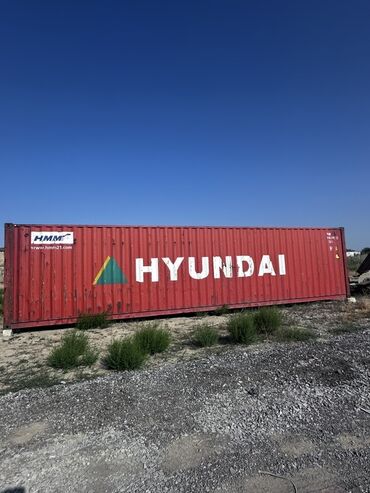 Qırmızı rəngdə, üzərində "HYUNDAI" yazısı olan dəniz konteyneri. Yük