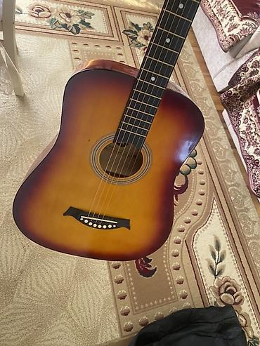 Üstündə çanta, divardan asılqan və simlər verilir Akkustik gitara –