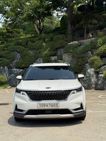 тойота карнавал: Элегантный белый минивэн Kia Carnival, представленный на снимках