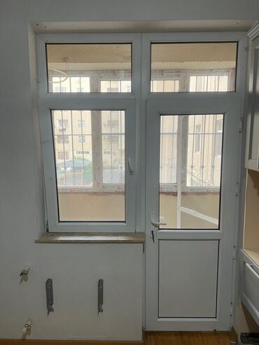 Ağ rəngdə, pəncərə və qapıdan ibarət balkon bloku. Pəncərə hissəsi