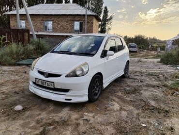 купить авто в кредит без первоначального взноса: Белый хэтчбек Honda Fit с пятидверным кузовом, идеально подходящий для