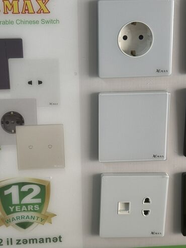 abşivka: XMAX brendinə məxsus ağ rəngli elektrik prizləri və açarları. Bu