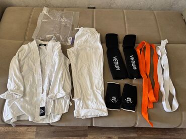 Ağ rəngdə Adidas markalı döyüş sənəti forması, həm üst hissədən, həm