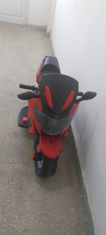 uşaq maşınları işlənmiş: Qırmızı və qara rənglərdə olan uşaq elektrik motosikleti. Uşaqların