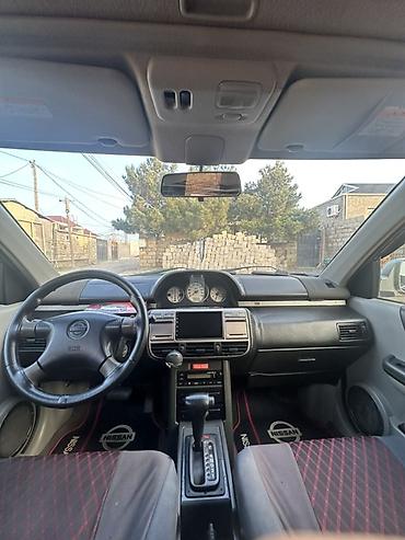 99 masin: Nissan X-Trail kompakt SUV modeli. Şəkillərdən göründüyü kimi gümüşü — 2