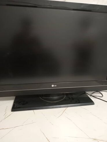 тумбочка с телевизором: Черный плоский телевизор LG с широким экраном и матовой поверхностью
