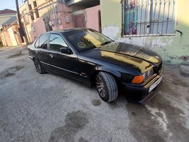 disklərin satışı: Bu, dörd qapılı, qara rəngli BMW E36 sedan modelidir. Avtomobilin