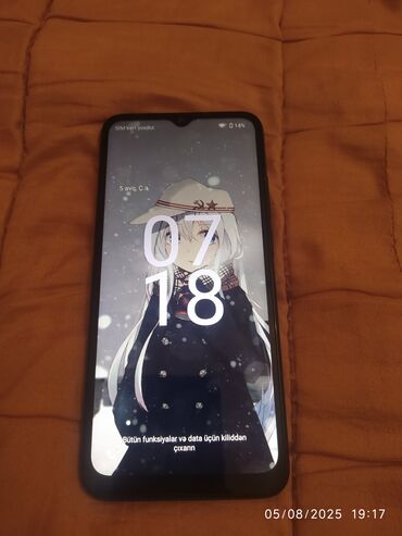Ekranında anime personajı olan qara rəngli smartfon. Cihazın yuxarı