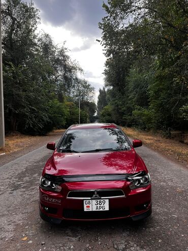 спортивный авто: Автомобиль Mitsubishi Lancer красного цвета, представленный в