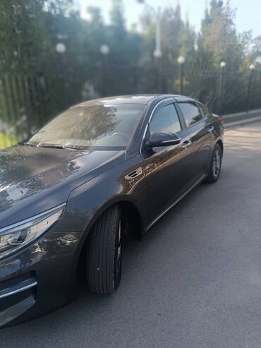продаю нексиа: Элегантный седан Kia K5 темного цвета, припаркованный на улице