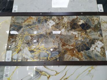 Quru inşaat materialları: Bu mərmər effekti ilə dizayn edilmiş keramik plitə, qızılı damarları