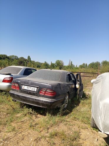 разбитые машины: Седан Mercedes-Benz E 320 в черном цвете. Модель принадлежит к линейке