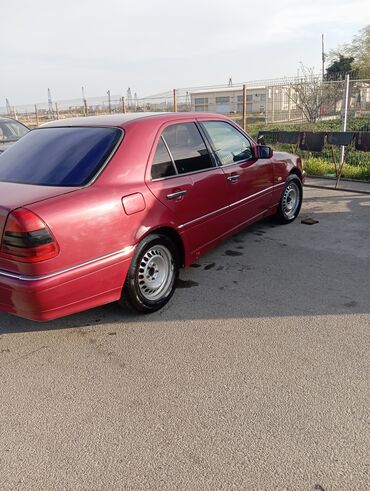 on suse: Mercedes-Benz C-Class model avtomobil, qırmızı rəngdə. Avtomobilin