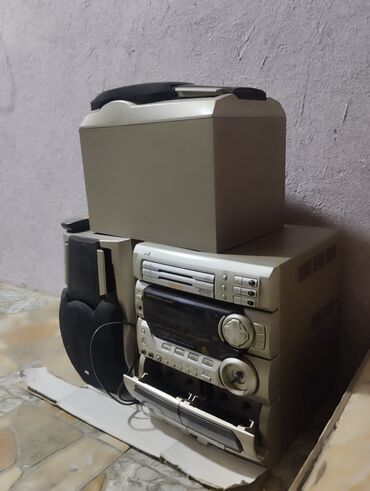 ev əşyaları işlənmiş: JVC stereo sistem, üst hissəsində sabvufer və sağ tərəfində əsas audio