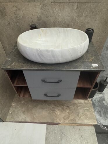 Hamam üçün kranlar: Ağ rəngli, mərmər teksturalı oval formalı lavabo, qara rəngli səthə