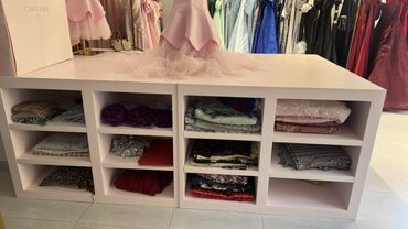 Manekenlər: Açıq rəngli, çox bölməli vitrin dolabı. Butik və ya mağaza kimi