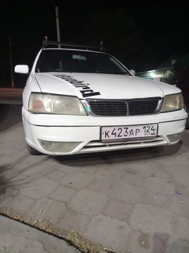 07 симёрка: Автомобиль Nissan Cefiro белого цвета. Установлен багажник на крыше и