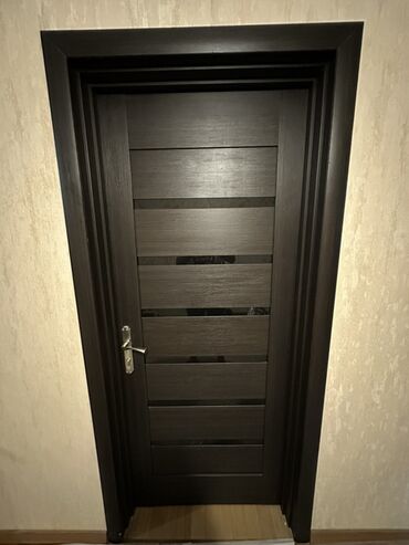 Bunker qapıları: Tünd qəhvəyi rəngdə, müasir dizaynda, şüşəli panelləri olan qapı. Bu
