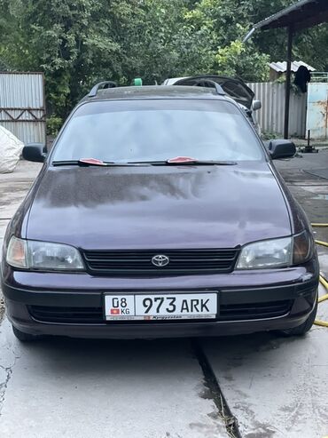 красные машины: Универсал Toyota Carina E в темно-фиолетовом цвете, оснащенный