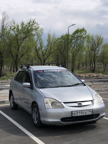 обмен дома: Серебристый хэтчбек Honda с багажником на крыше. Автомобиль оснащен