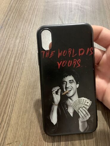 Pianolar: Qara rəngli telefon qabı. Arxa tərəfdə qırmızı “THE WORLD IS YOURS”
