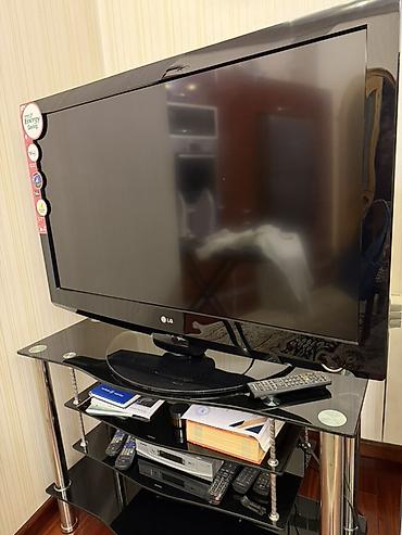 tv box kanallar: LG LCD/LED televizor, təxminən 37–42” diaqonal ekran. Qara korpus — 1