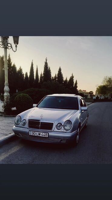 belarus mtz 82.2: Gümüşü rəngdə olan Mercedes-Benz E-Class sedanı. Avtomobil səliqəli