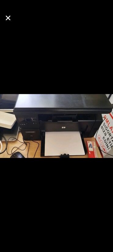 Masaüstü kompüterlər və iş stansiyaları: HP brendinə məxsus qara rəngli printer. Bu printer sənədlərin çapı
