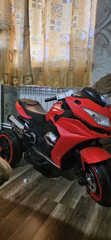 Uşaqlar üçün nəzərdə tutulmuş qırmızı rəngli elektrik motosiklet. İki