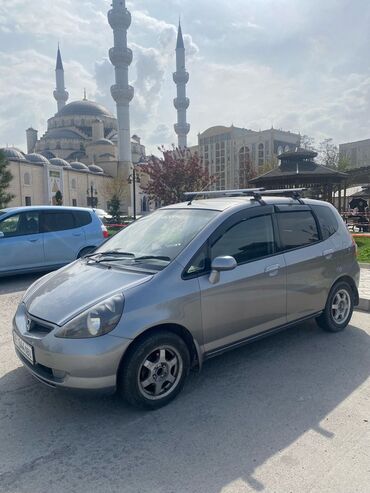 скупка авто в любом состоянии: Хэтчбек Honda Fit серебристого цвета, оснащенный багажником на крыше