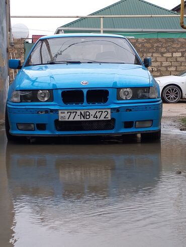 диски на бмв х5 е53: Mavi rəngli, dördqapılı BMW avtomobili. Avtomobilin ön hissəsində qara